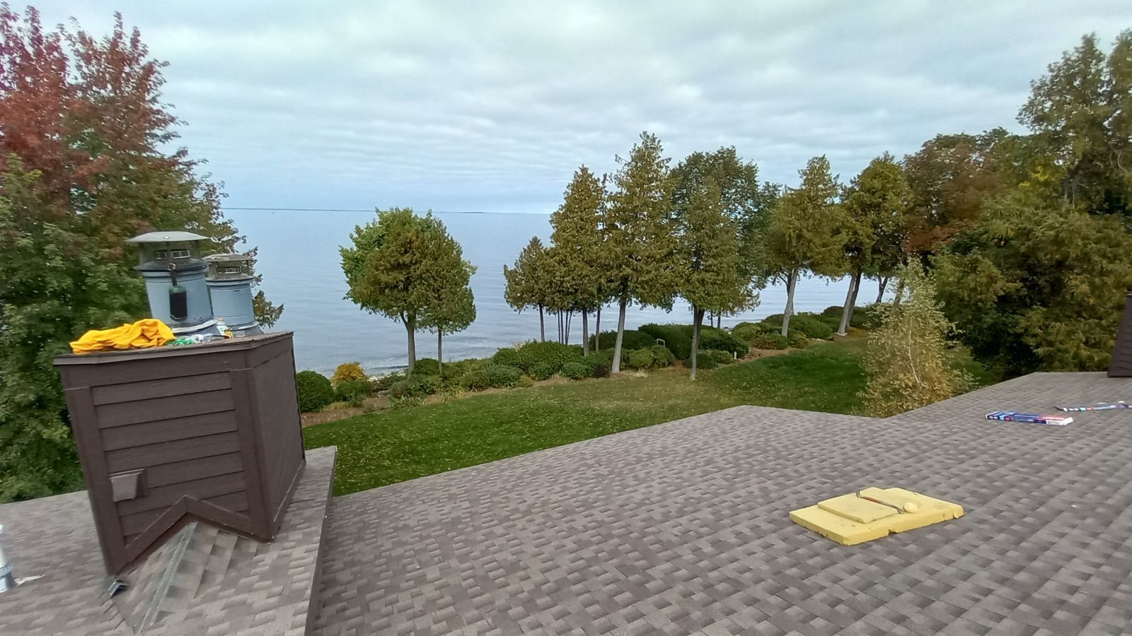 A rooftop with a view of a lake and trees.