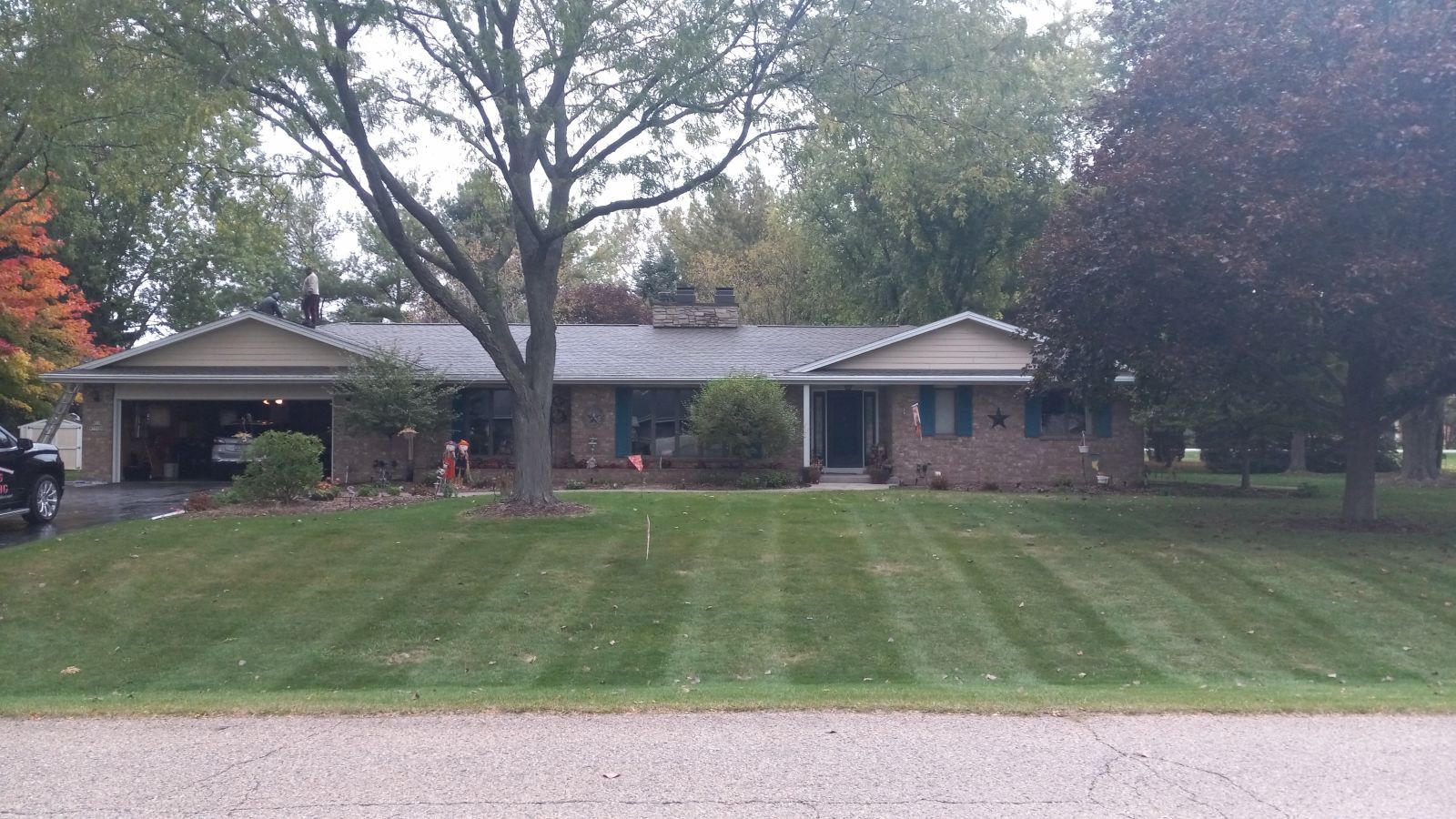 A house with a lush green lawn and a truck parked in front of it.