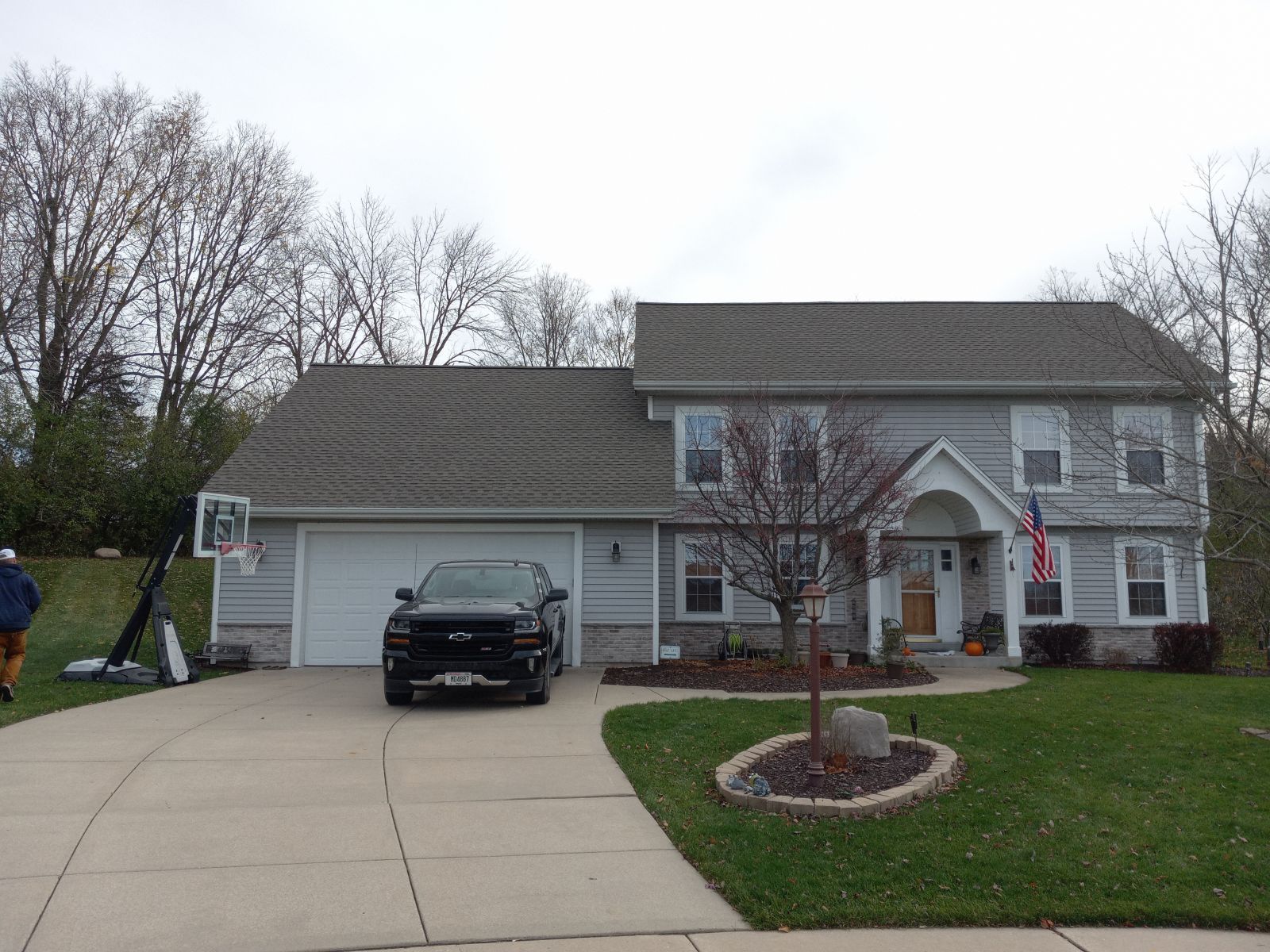 A black truck is parked in front of a large house