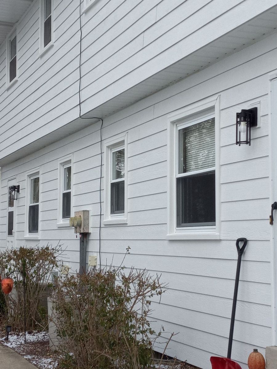 A white house with a snow shovel in front of it