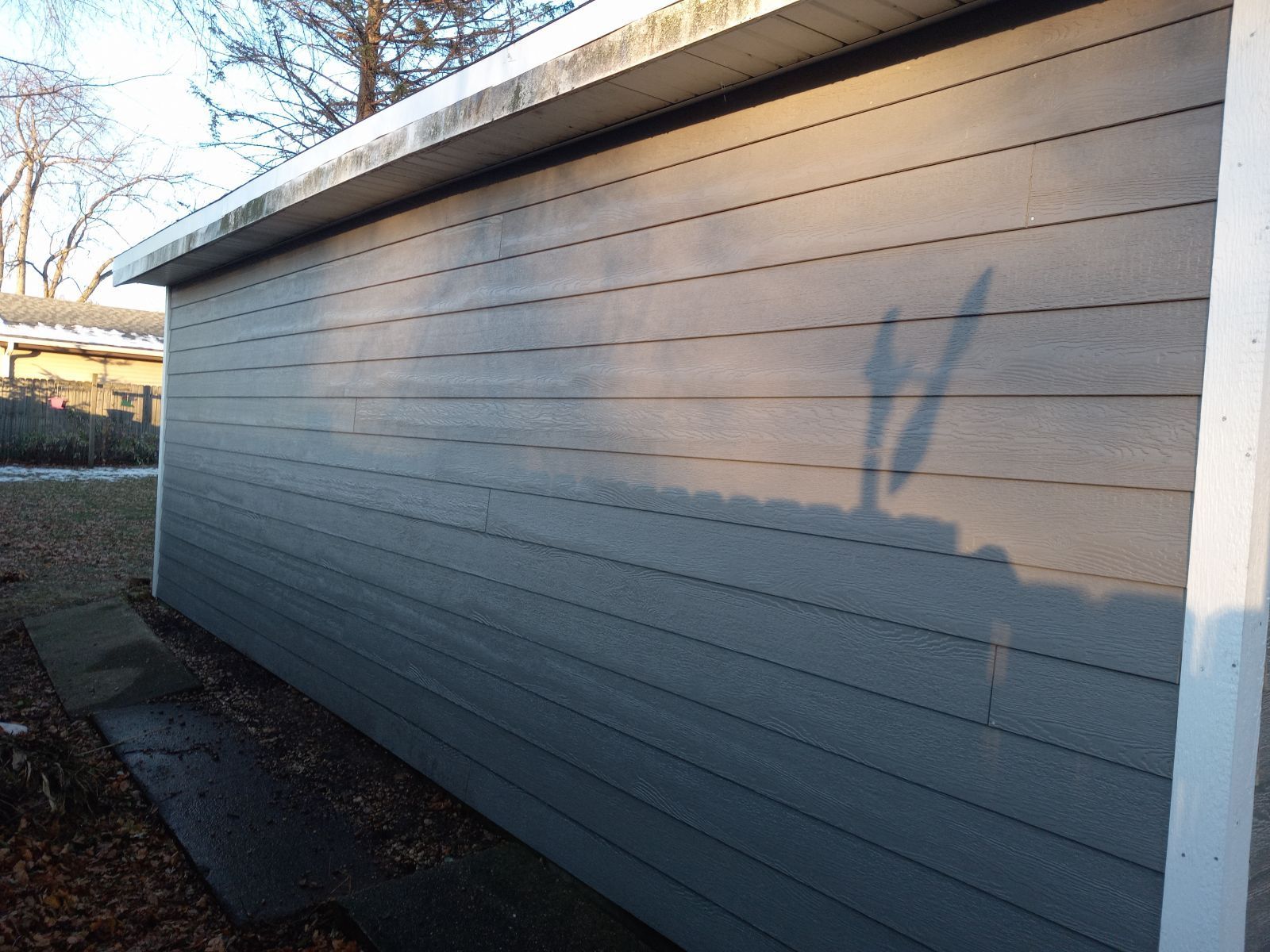 A shadow of a person is cast on the side of a building