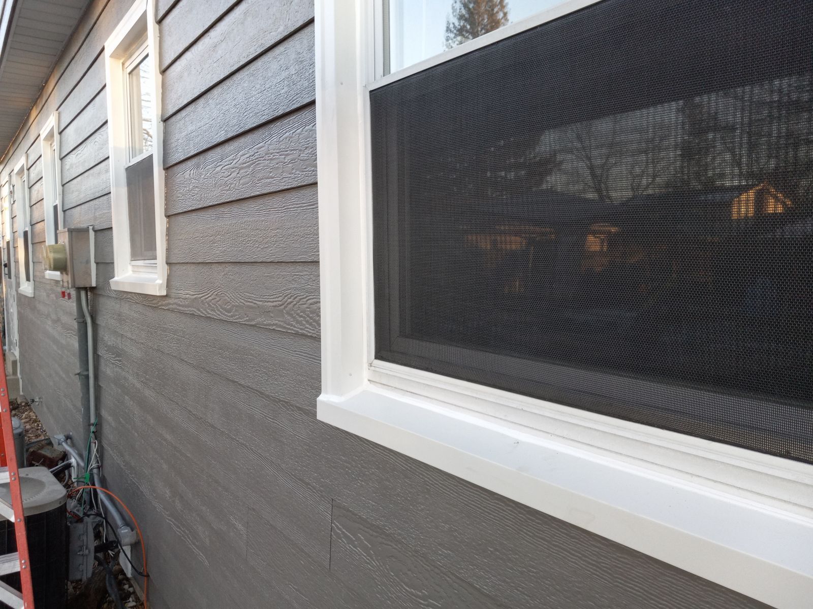 A house with a screened in window on the side of it.