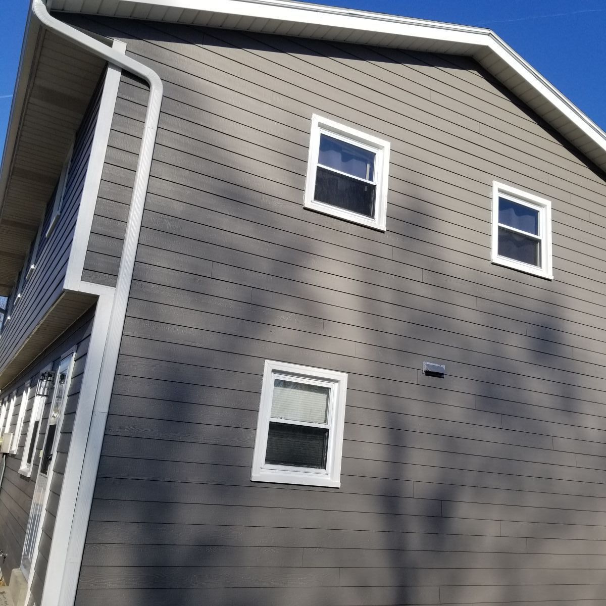 A large house with a lot of windows and a gutter on the side of it.