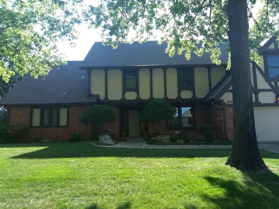 A large brick house with a tree in front of it
