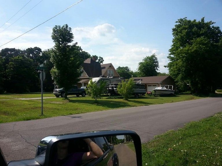 A car is parked on the side of the road in front of a house
