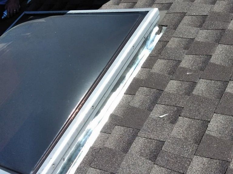 A skylight on top of a roof with shingles