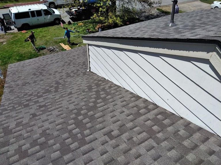 A man is working on the roof of a house.