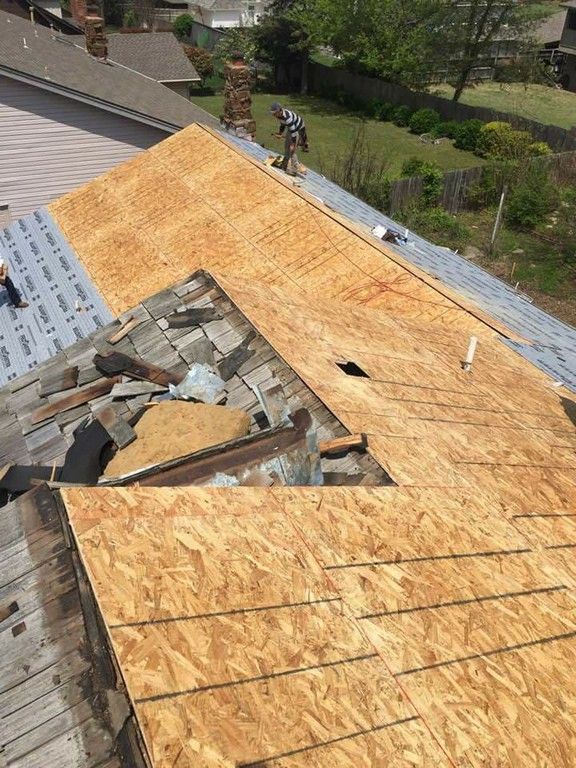 A man is working on the roof of a house.