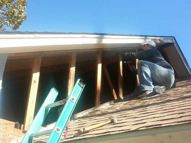 A man is working on the roof of a house.