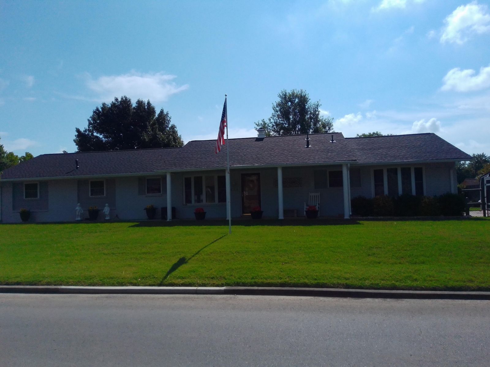A large white house with a porch and an american flag