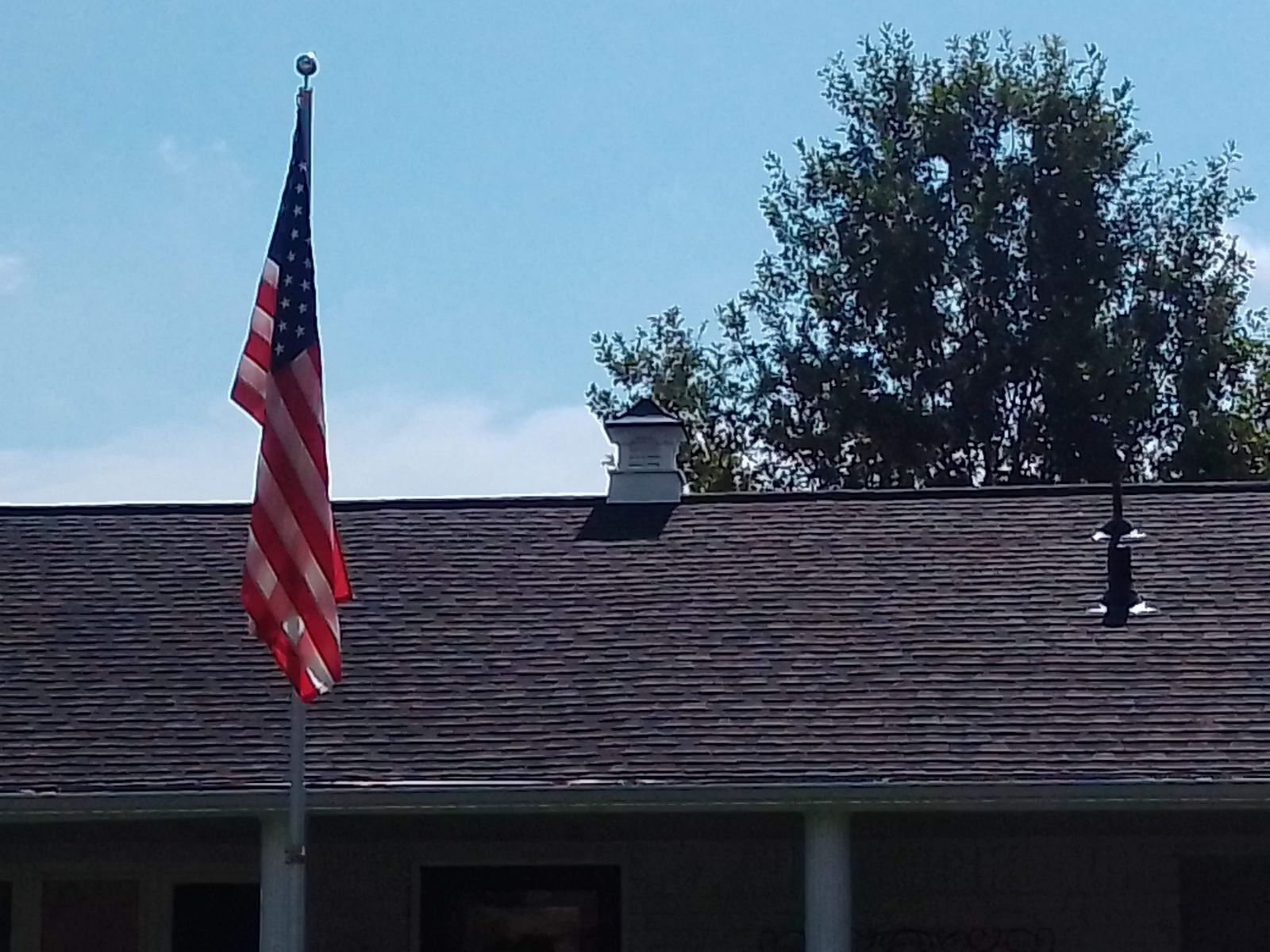 An american flag is flying in front of a house