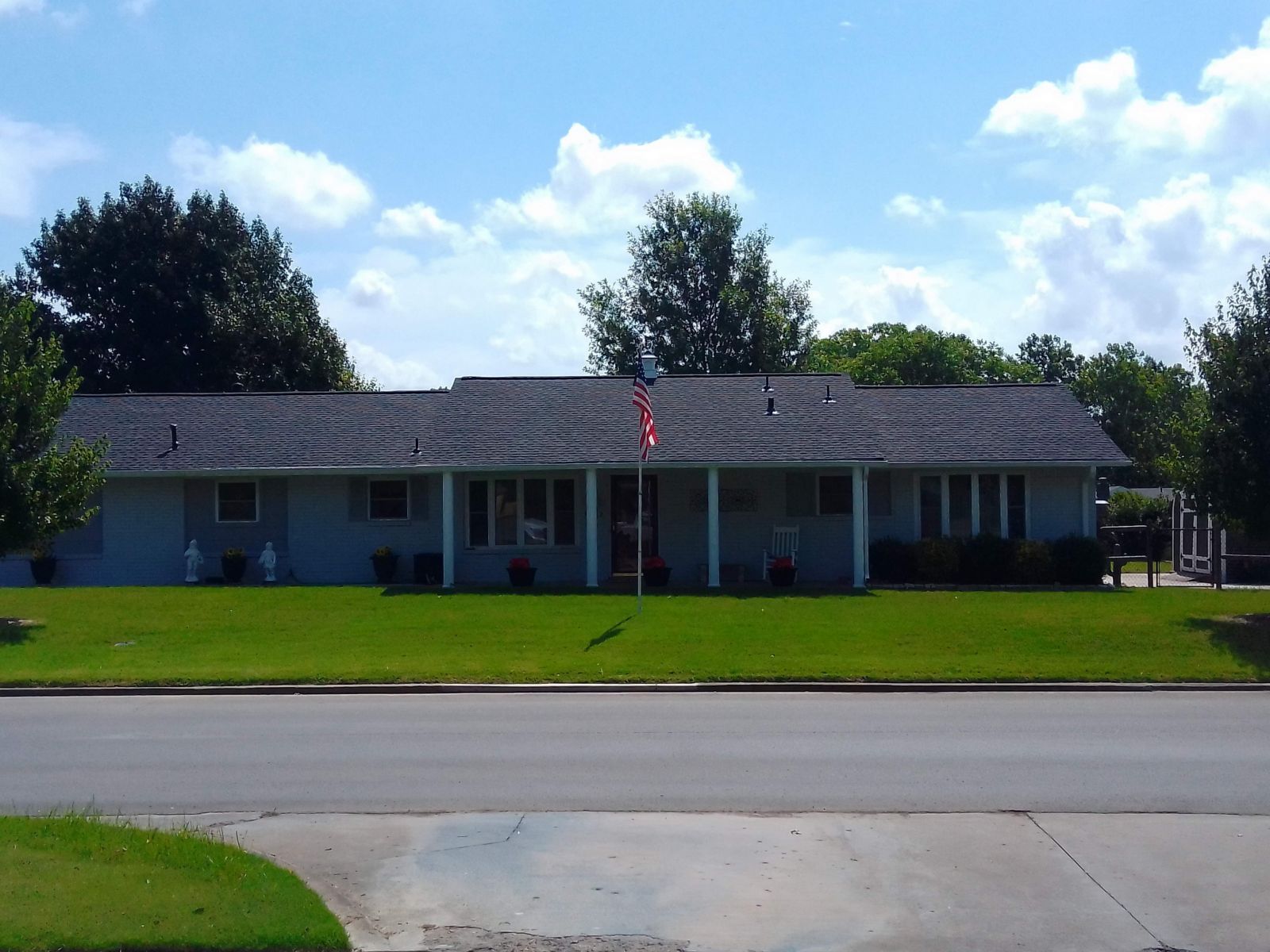A house with a porch and a flag on top of it