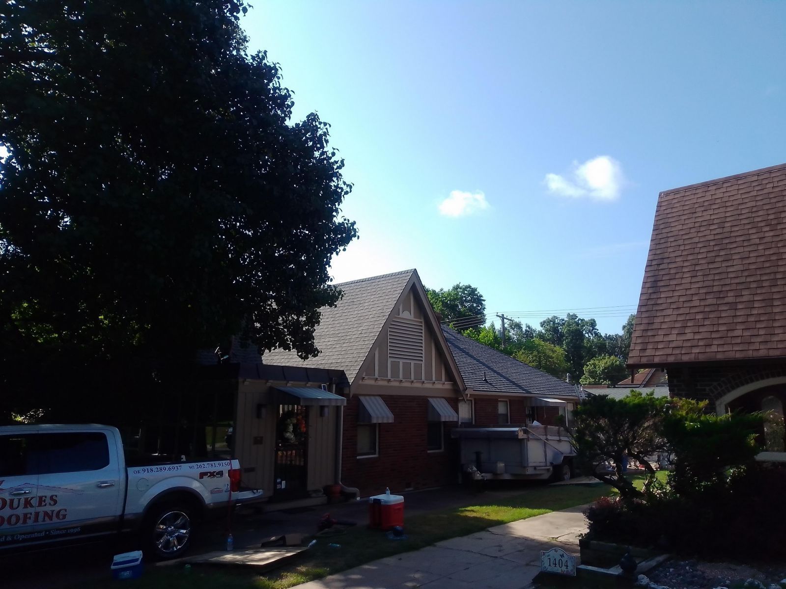A white truck is parked in front of a house.