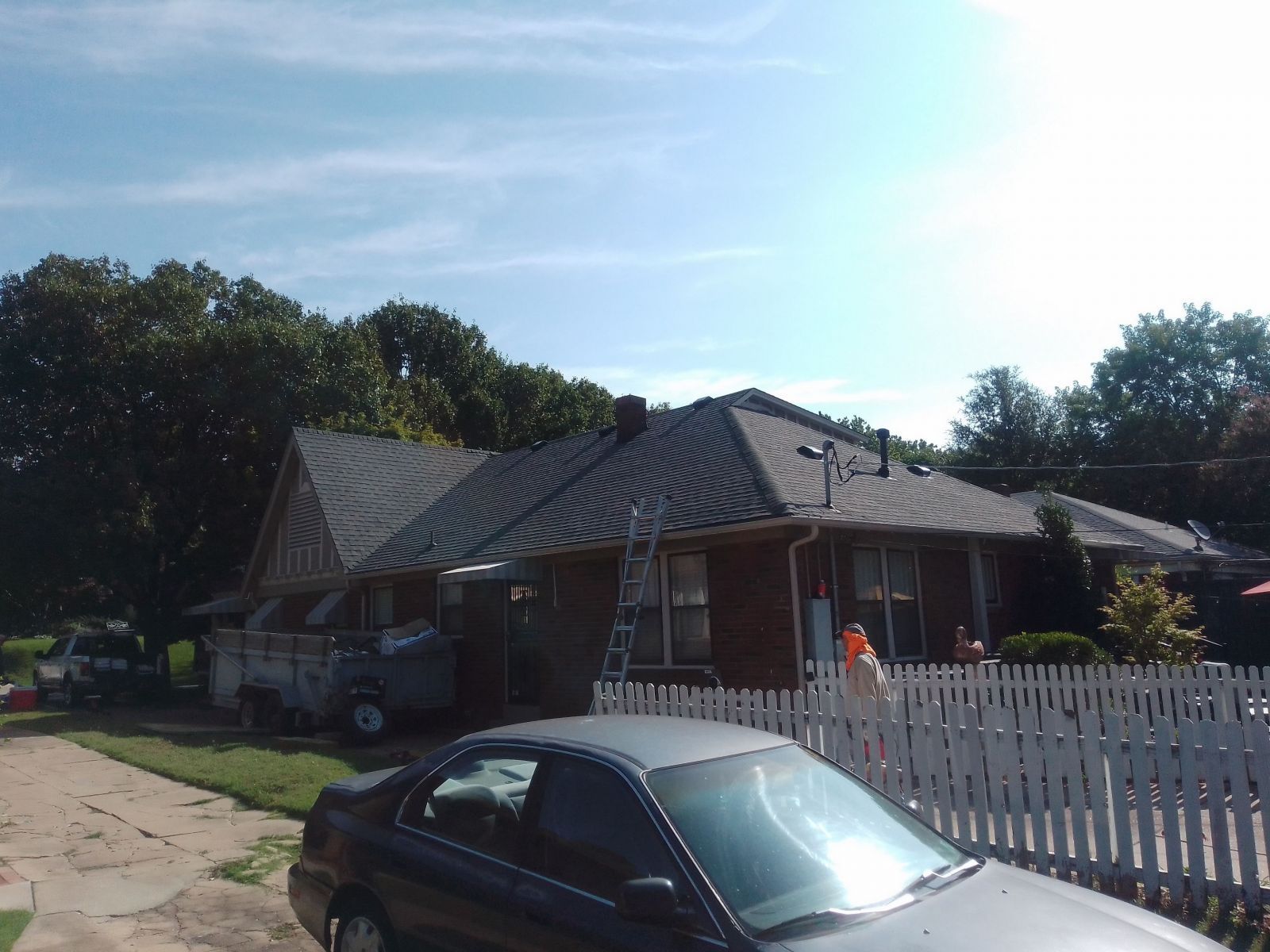 A black car is parked in front of a house