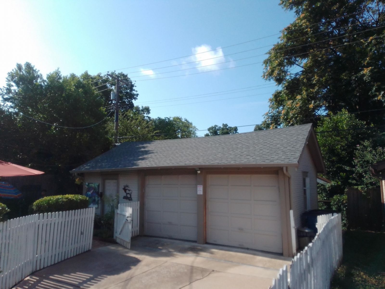 A garage with a white picket fence surrounding it