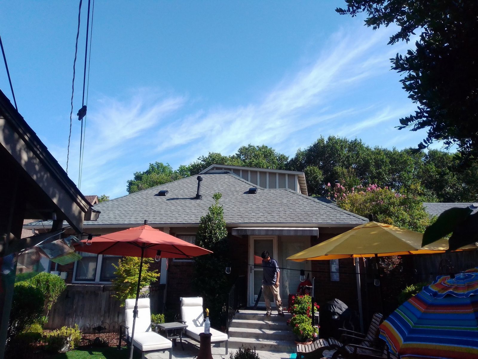 A house with umbrellas and chairs in front of it