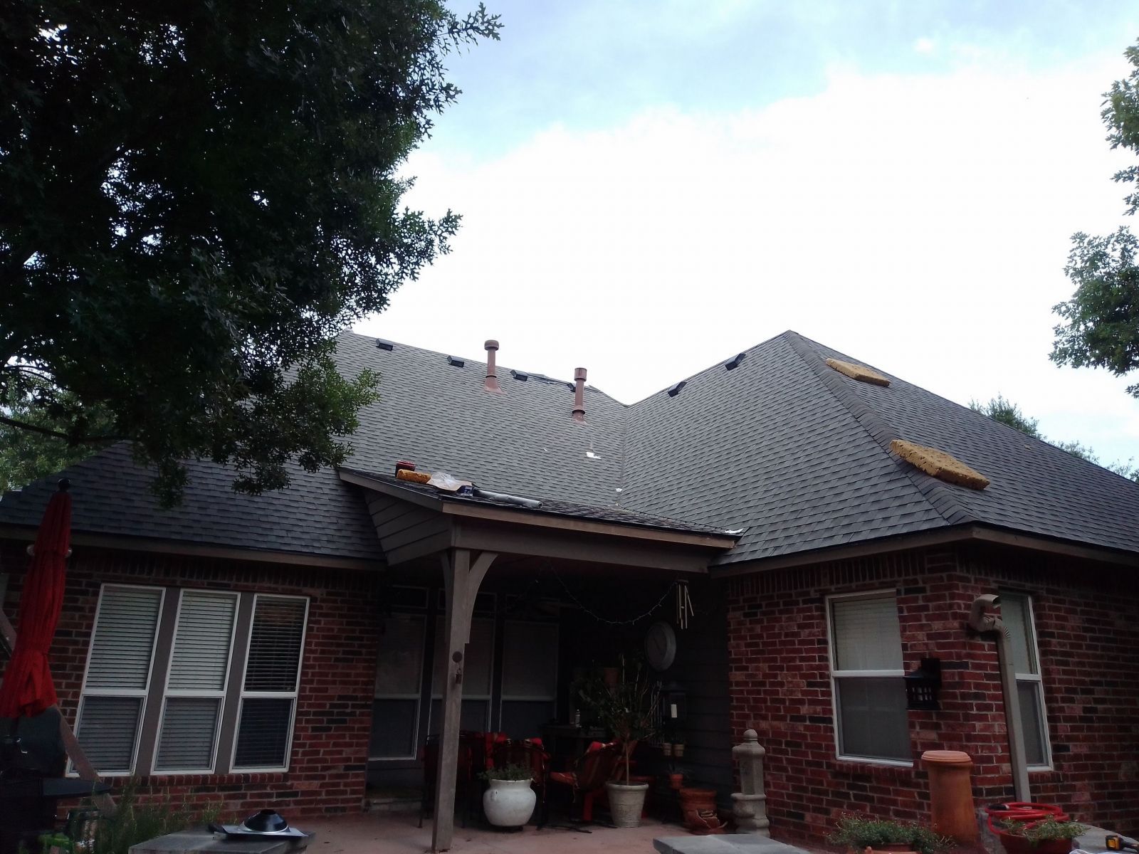 A brick house with a roof that is being repaired