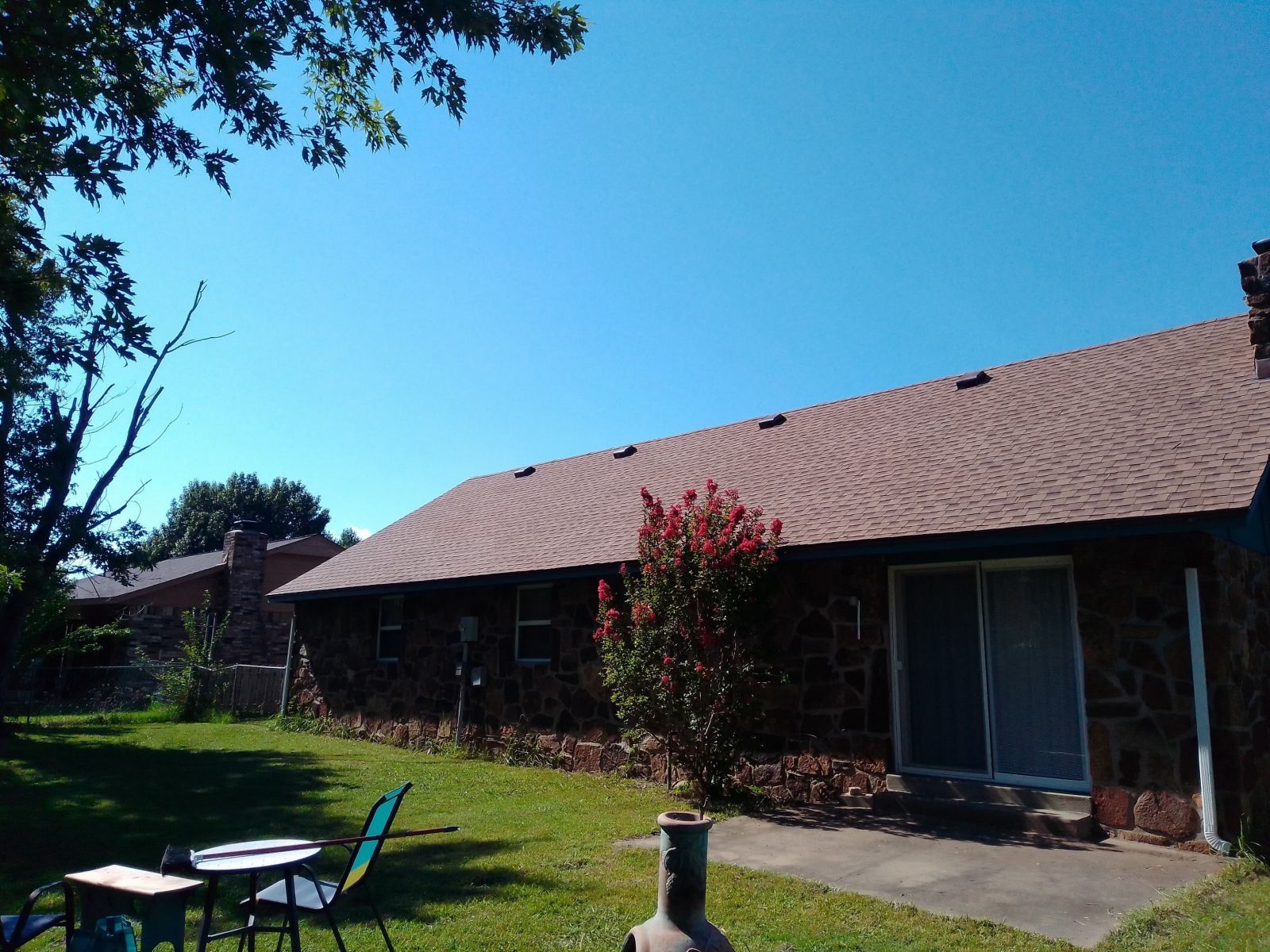 A house with a table and chairs in the backyard