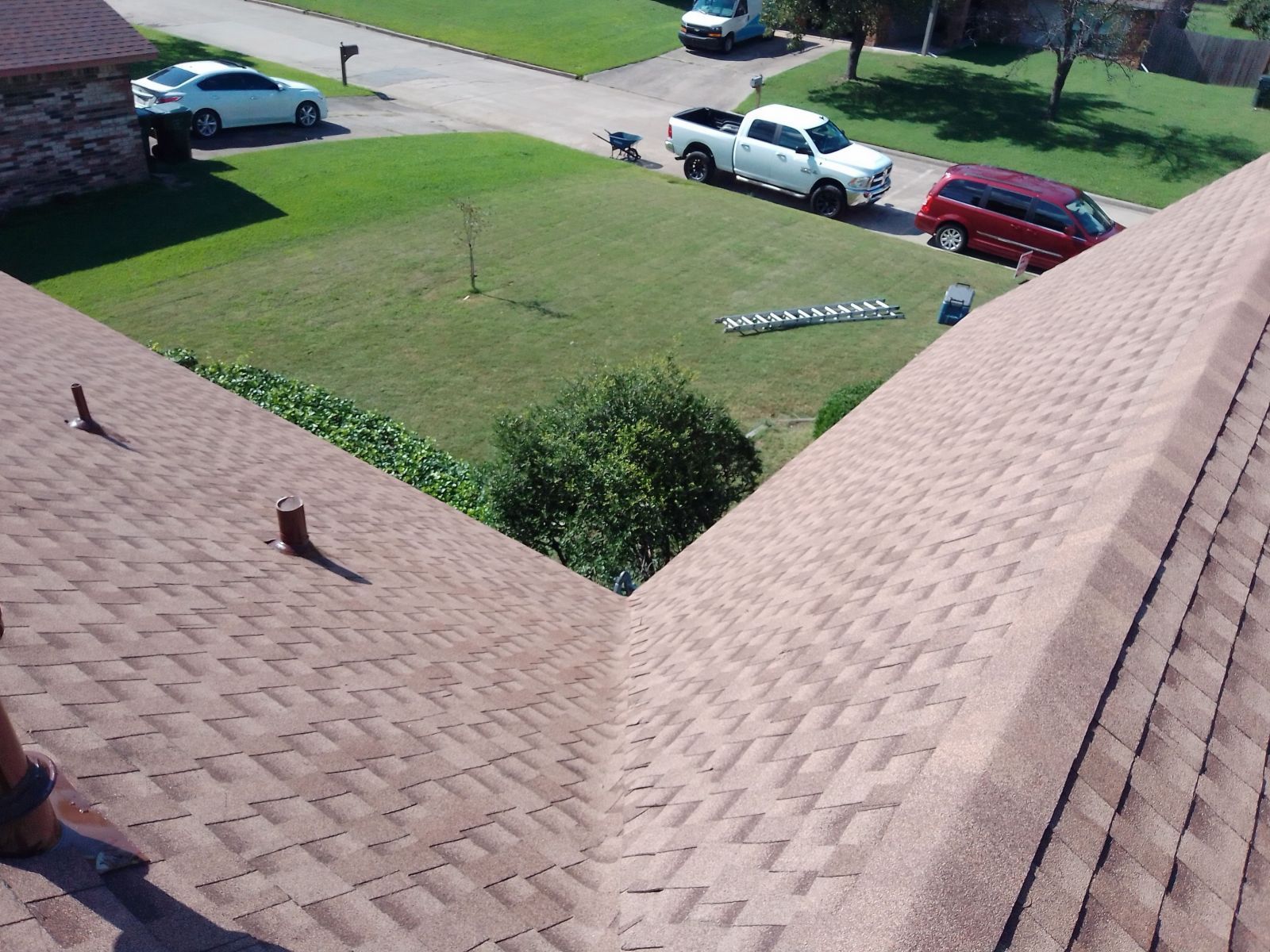 A truck is parked on the roof of a house in a residential area.