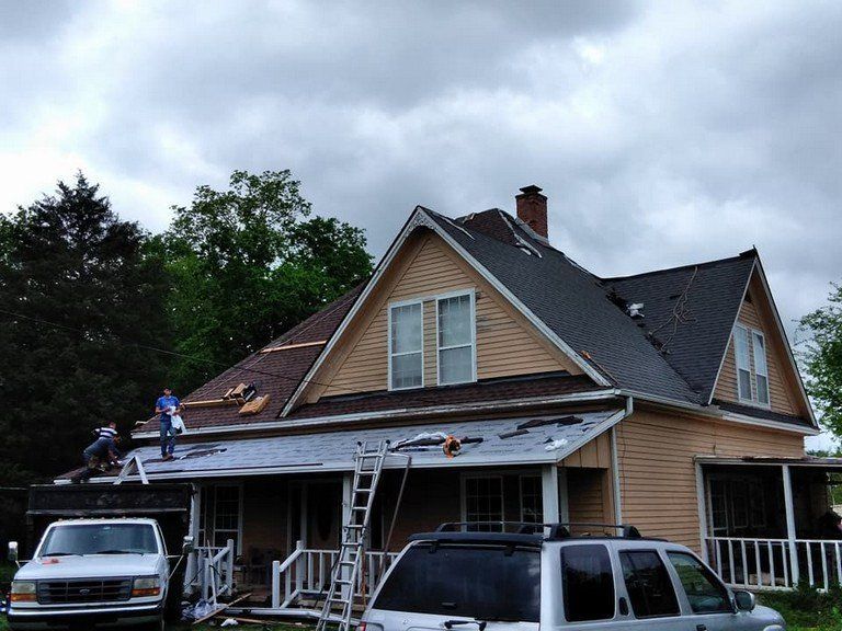 A white van is parked in front of a house that is being remodeled