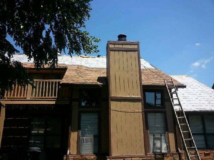 A house with a chimney and a ladder in front of it