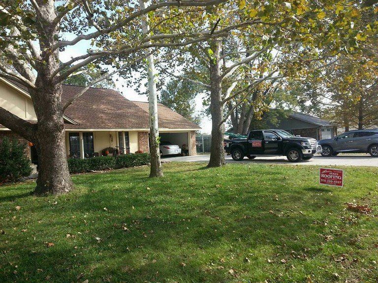 A black truck is parked in front of a house.
