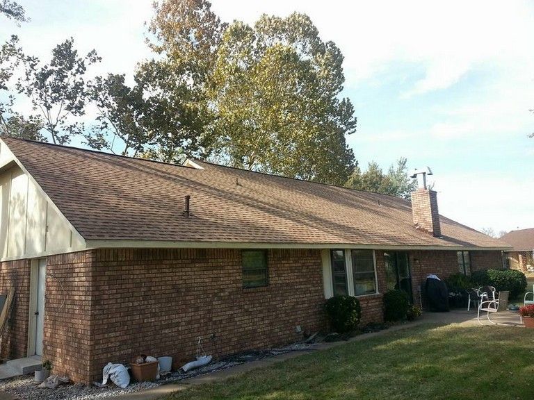 A brick house with a brown roof and a chimney