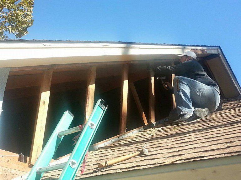 A man is working on the roof of a house