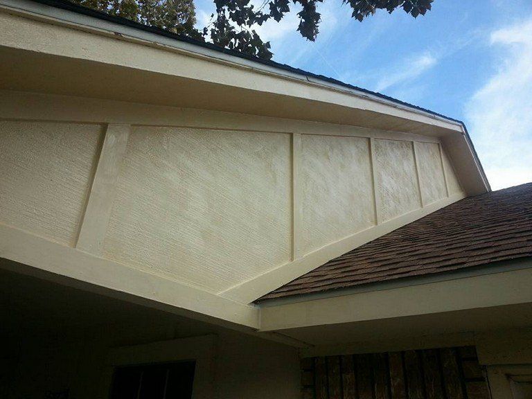A white house with a brown roof and a blue sky in the background