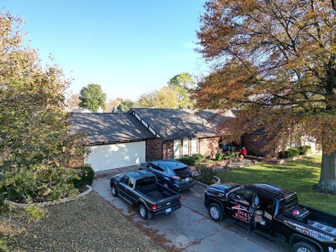 A couple of trucks are parked in front of a house.