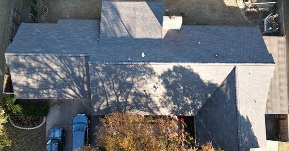 An aerial view of a house with a blue truck parked in front of it.