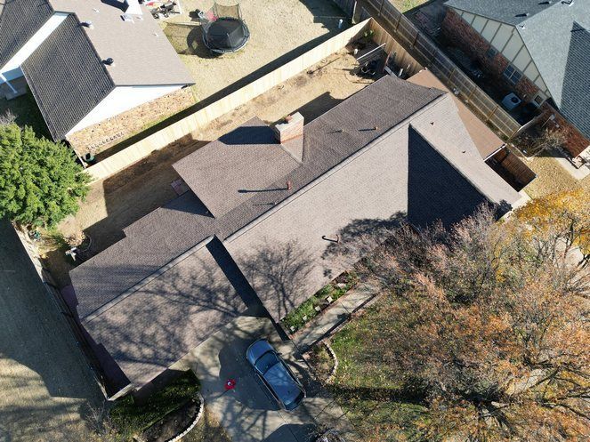 An aerial view of a house with a car parked in front of it