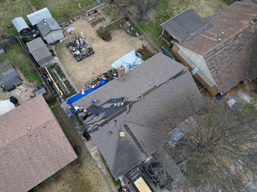 An aerial view of a house with a roof being repaired.