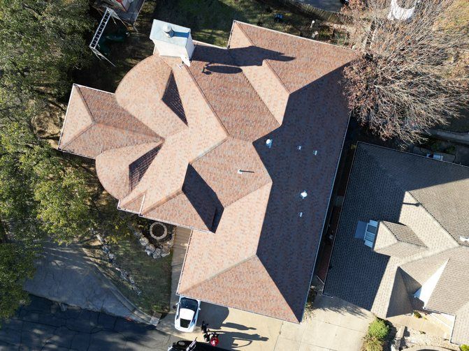 An aerial view of a house with a roof that looks like a snowflake.