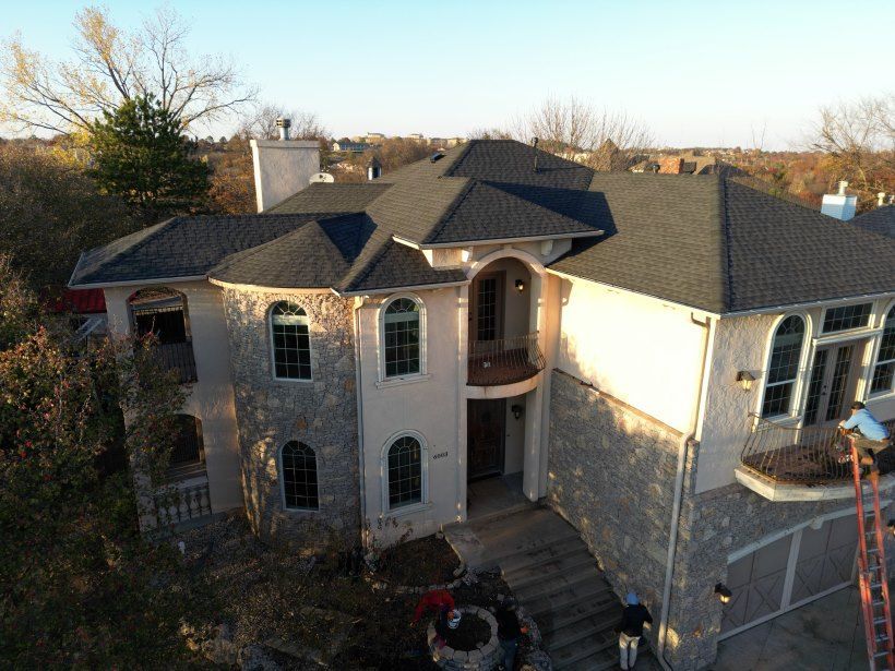 An aerial view of a large house with a gray roof.