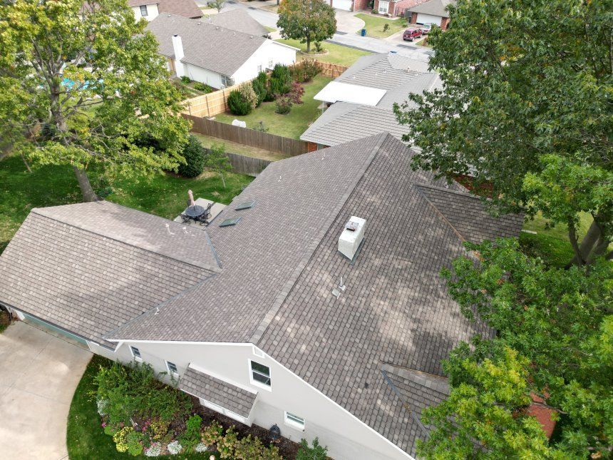 An aerial view of a house with a roof that is being repaired.