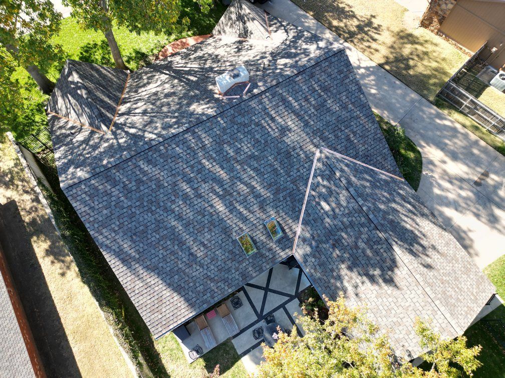 An aerial view of a house with a roof that is being repaired.
