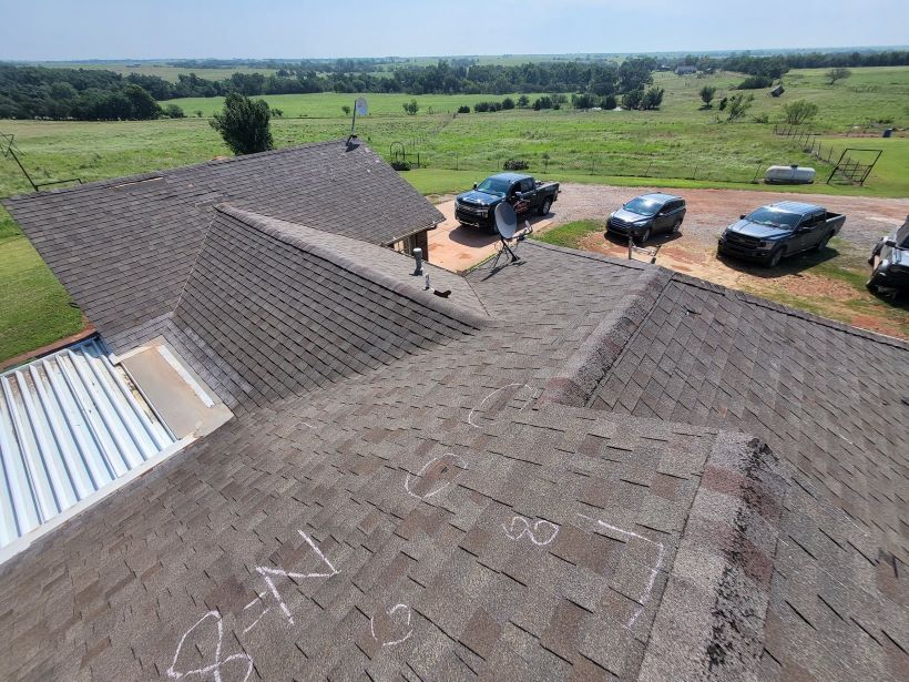 An aerial view of a roof with a few cars parked on it.