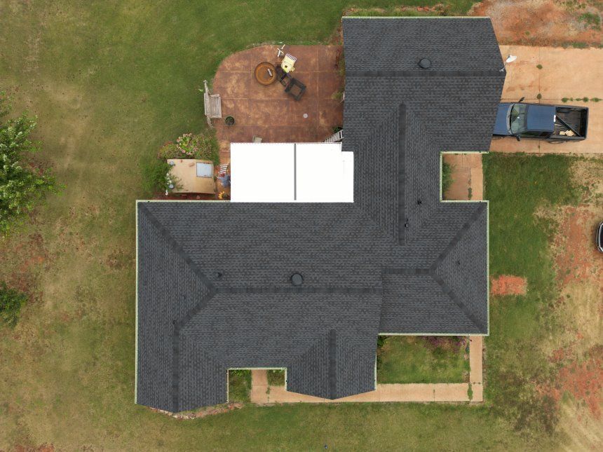 An aerial view of a house with a blue truck parked in front of it