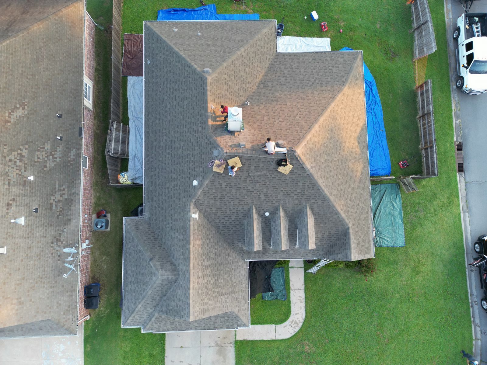An aerial view of a house with a roof being repaired.