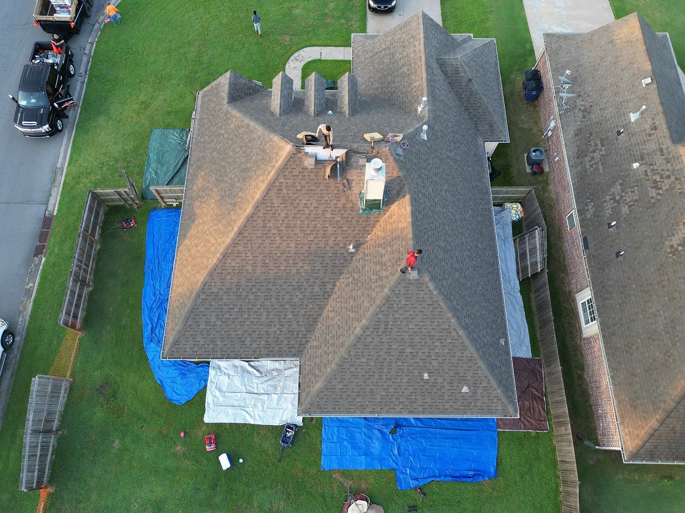An aerial view of a house with a roof being repaired.
