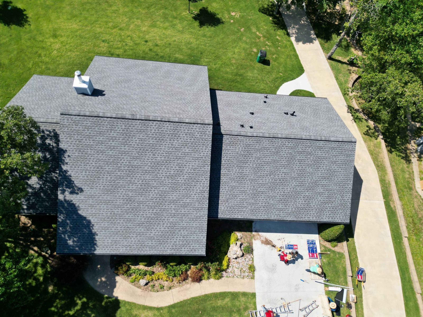 An aerial view of a house with two roofs and a driveway.