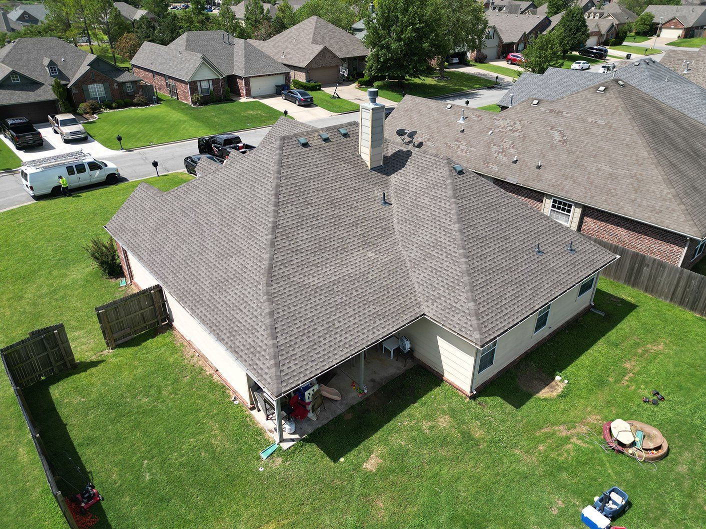 An aerial view of a house with a new roof in a residential area.