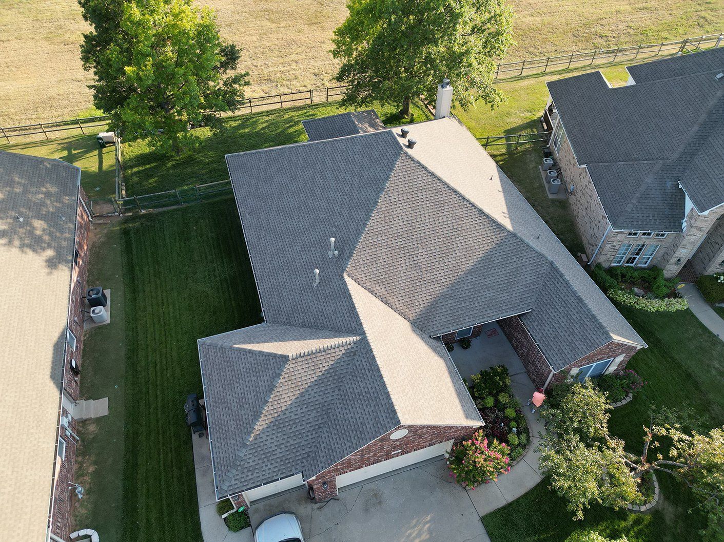 An aerial view of a house with a roof that is covered in shingles.