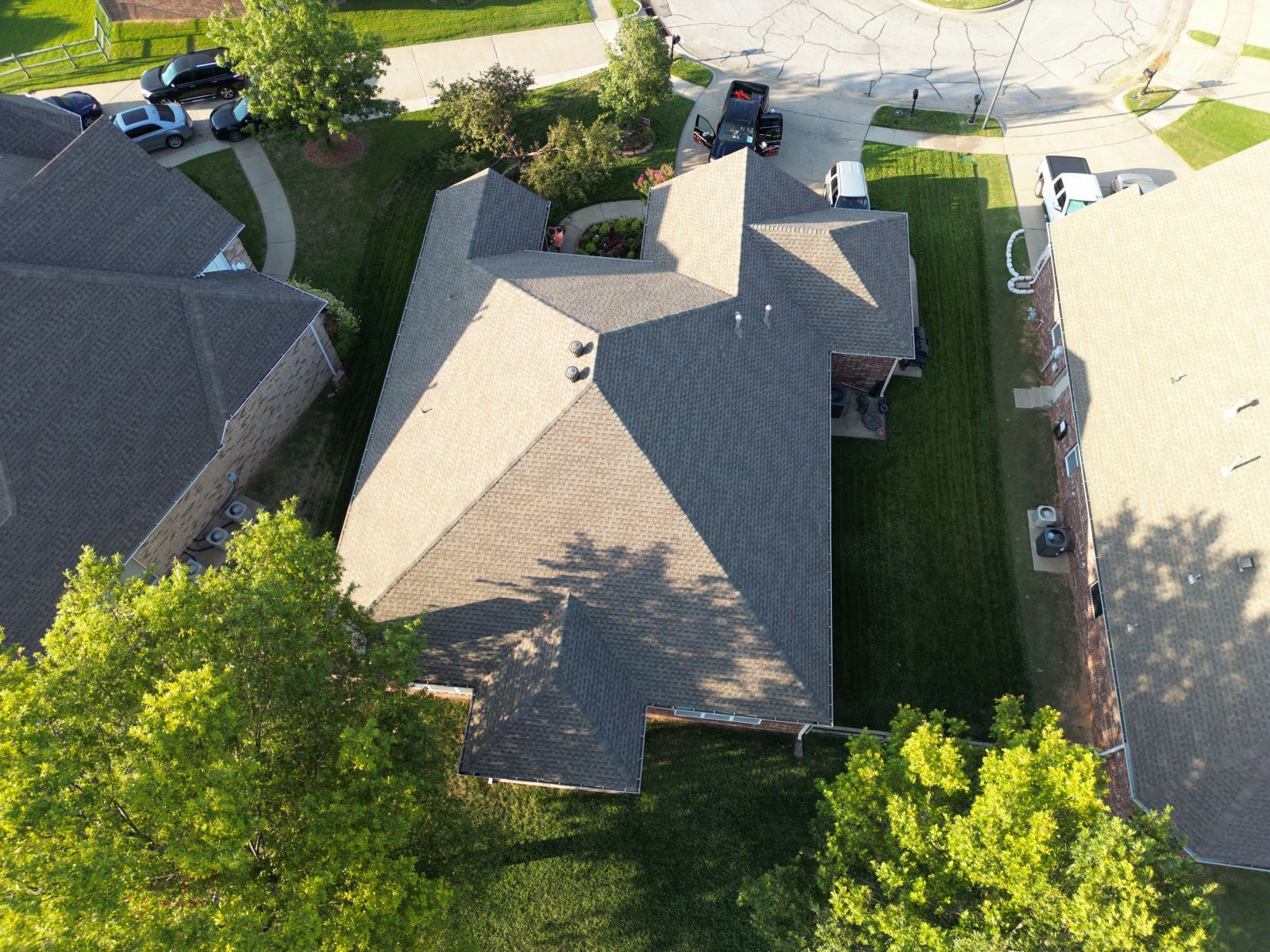 An aerial view of a house with a roof in a residential area.