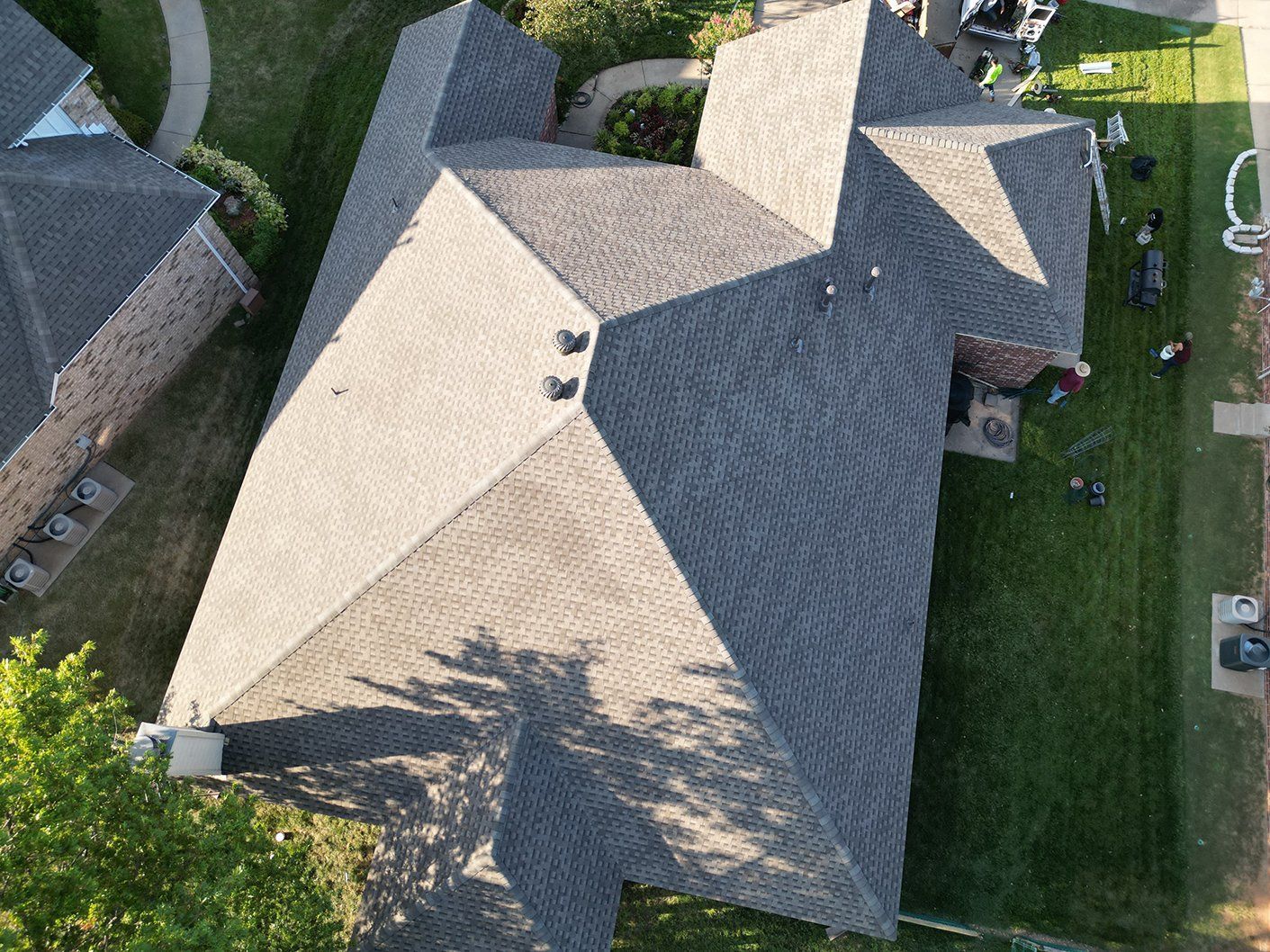 An aerial view of a house with a roof in a residential area.