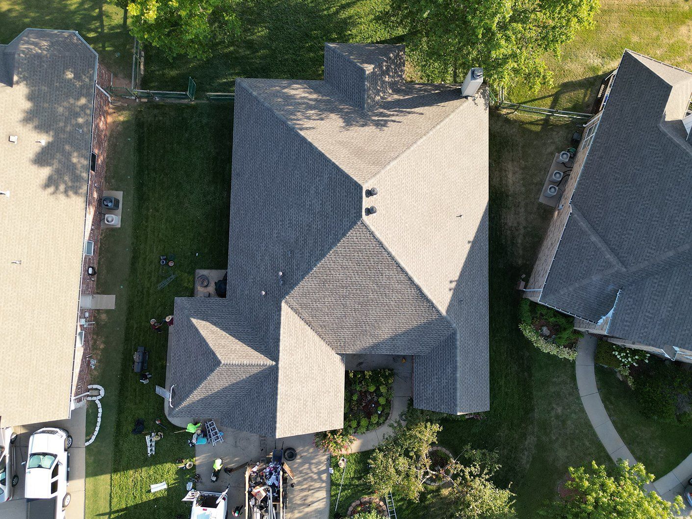 An aerial view of a house with a roof in a residential area.