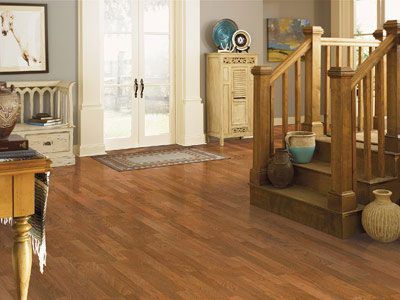 A living room with hardwood floors and a wooden staircase.