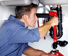 Plumber working under sink