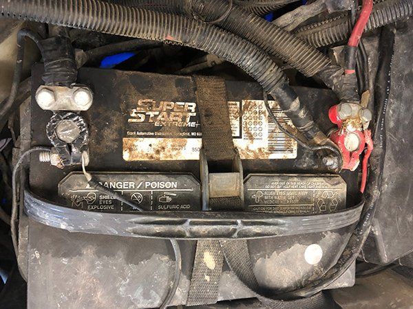 A super start battery is sitting in the trunk of a car.